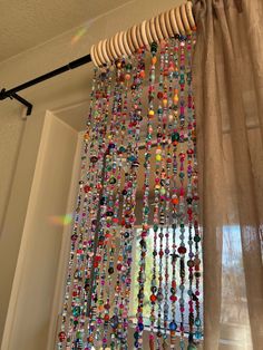 a curtain with beads hanging from it's side in front of a window sill