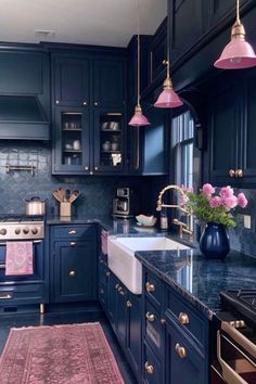 a kitchen with blue cabinets, pink rug and gold accents on the countertops is seen in this image