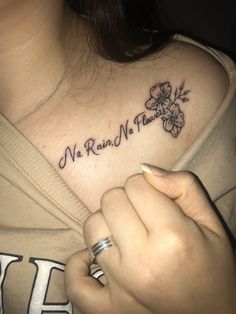 a woman with a flower tattoo on her chest and the words no rain, no flowers written in cursive font