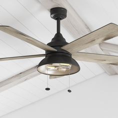 a ceiling fan that is hanging from the ceiling in a room with white walls and wood beams