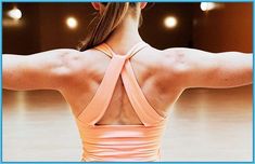 a woman with her back turned to the camera, wearing a pink sports bra top