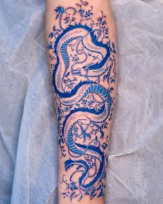 a blue dragon tattoo on the left arm and leg, with an intricate design in it