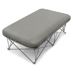 a small bed with a gray cover on it's side and metal frame legs