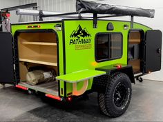 an off road camper trailer with the door open and storage compartment on it's side