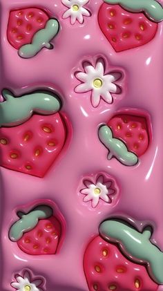 some pink and green strawberry shaped chocolates with flowers on them