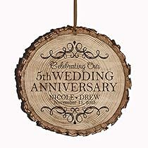 a wedding anniversary ornament hanging from a wooden slice with the words, celebrating on it