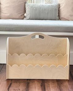 a wooden shelf sitting on top of a hard wood floor next to a white couch