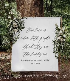 a white wedding sign with greenery on it and the words, true love is when people think they are the only one