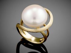 Thank you for looking at my Handmade "Saturn" - 18K gold ring, set with a 16 mm, Bouton Pearl, Unique Design. This ring is a part of our "Classic" collection "Marked with modernity, simplicity, and sophistication. The pearl is the centerpiece.  It is enhanced by the gold but does not outshine the design's dynamic." If you are looking for a different and unique piece of jewelry you have come to the right place. I chose to study jewelry design with a great desire to bring something different, a special and unconventional design, a piece of jewelry that will stand the test of time. All my jewelry is made to order, made from the highest quality raw materials, using traditional techniques and a combination of advanced technologies  that give me the tools to produce almost any design. Optional t Ring Unique Design, Gold Ring Unique, Pearl Rings, Everyday Ring, Gold Ring Sets, Ring Pictures, Everyday Rings, 18k Gold Ring, Ring Unique