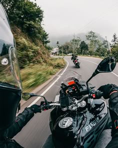 two motorcyclists riding down the road on their motorcycles