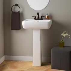 a white sink sitting under a mirror in a bathroom next to a wall mounted faucet