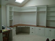 an empty room with white cabinets and shelves