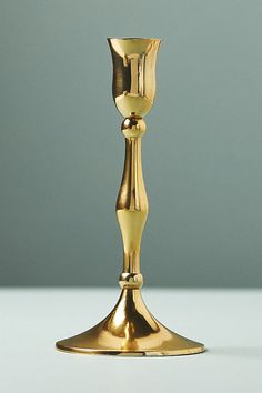 a golden candle holder on a white table