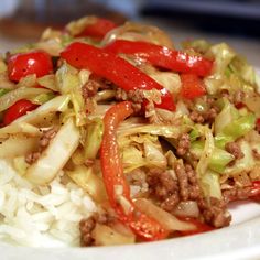 a white plate topped with meat and vegetables on top of rice covered in seasoning