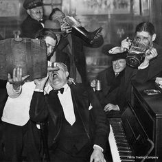 an old black and white photo of men in tuxedos holding up suitcases