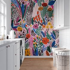 a kitchen with colorful wallpaper and white cabinets