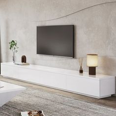 a flat screen tv mounted to the side of a white entertainment center in a living room