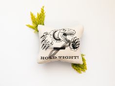 a white pillow with an image of a bird on it and the words hold tight