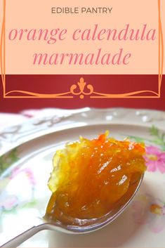 an orange calendula marmalade is on a plate with a spoon in it