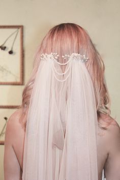 a woman with pink hair wearing a veil