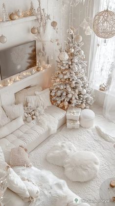 a living room with white furniture and christmas decorations