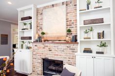 a living room filled with furniture and a fire place in front of a brick fireplace