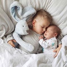 a baby sleeping next to a stuffed animal