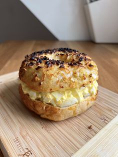 an egg and cheese sandwich on a wooden cutting board