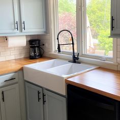 a white kitchen sink sitting under a window