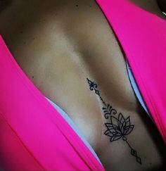 a woman with a tattoo on her chest is wearing a pink top and has an arrow in the middle