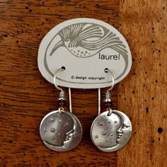 "There are quite a few moonface earrings in Laurel's line - these are the most petite ones available. Brass with either gold or sterling silver plate, about 1.5\" (2 fingers) tall. French hooks accented with red glass bead. The revival earrings here are vintage stock from the 1970's - they were designed by the late artist Laurel Burch and crafted by hand." Celestial Nickel-free Earrings, Celestial Nickel-free Adjustable Earrings, Adjustable Celestial Nickel-free Earrings, Unique Adjustable Earrings With Moon Charm, Silver Moon Charm Earrings For Everyday, Everyday Silver Earrings With Moon Charm, Sterling Silver Moon Charm Earrings For Everyday, Adjustable Moon-shaped Sterling Silver Earrings, Symbolic Moon Shaped Sterling Silver Earrings