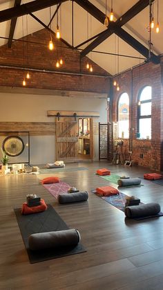 yoga mats are laid out on the floor in a large room with exposed ceiling lights