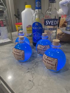 three blue bottles sitting on top of a counter