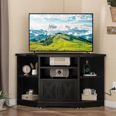 a flat screen tv sitting on top of a black entertainment center next to a window