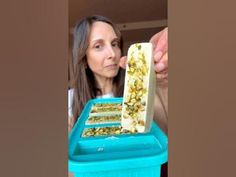 a woman is looking at some food in a bin