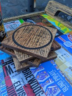 three wooden coasters sitting on top of each other next to a can of beer