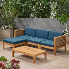 a blue couch sitting on top of a wooden table next to a planter filled with flowers