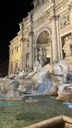 the trellotto fountain is lit up at night with statues on top and below it