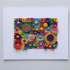 an art piece made out of paper with colorful flowers on the top and bottom half