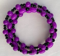 This bracelet is comprised of various shapes of hot purple beads along with various shapes and sizes of shiny black beads.  This pretty bracelet is made with spiraled memory wire so it will fit everyone!  It makes a great gift because you don't have to know someone's wrist size for it to be the perfect fit.    The matching earrings in picture #6 can be found at this link: https://www.etsy.com/listing/1109337928/earrings-hot-purple-and-black-dangle The matching necklace in picture #7  is here: ht Purple Beaded Bracelets With Black Beads As A Gift, Purple And Black Jewelry, Adjustable Purple Bracelets With Black Beads, Adjustable Purple Bracelet With Black Beads, Purple And Black Bracelet, Cheap Purple Hand-strung Beaded Bracelets, Purple Hand-strung Stretch Bracelet, Gray Bracelet, Black Bracelets