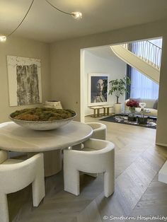 a large bowl sitting on top of a white table in a living room filled with furniture