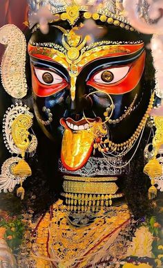 a painting of a mask with gold and black paint on it's face, surrounded by other items