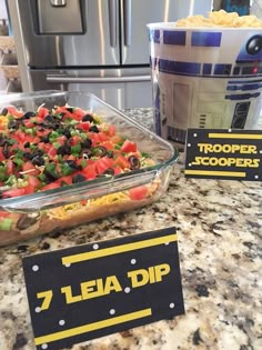 a bowl of food sitting on top of a counter next to a container of chips