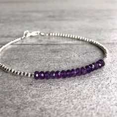 This delicate bracelet features small natural Amethyst gemstones. The faceted Amethyst beads are a beautiful vibrant purple hue. This piece is timeless, yet unique. A perfect gift for a birthday or for your Valentine. The tiny round beads frame the faceted gemstones beautifully. At checkout, choose to buy a Amethyst bracelet with gold or sterling silver beads. * METAPHYSICAL PROPERTIES OF AMETHYST * balance courage peace protection temperance wisdom Free gift with each crystal jewelry purchase f Handmade Purple Sterling Silver Beaded Bracelets, Amethyst Beaded Bracelets With Spacer Beads As Gift, Purple Sterling Silver Beaded Bracelets With Round Beads, Purple Rondelle Beaded Bracelets As Gift, Everyday Purple Amethyst Bracelet, Purple Gemstone Beaded Bracelets In Sterling Silver, Everyday Purple Hand-strung Jewelry, Amethyst Beaded Bracelet, Shiny Bracelets