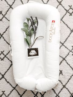 an inflatable baby seat with a plant growing out of it on the floor