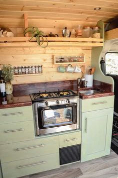 a kitchen with green cabinets and an oven