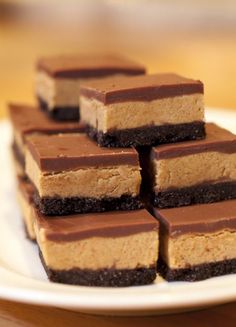 several pieces of chocolate and peanut butter cheesecake on a white plate with a wooden table in the background