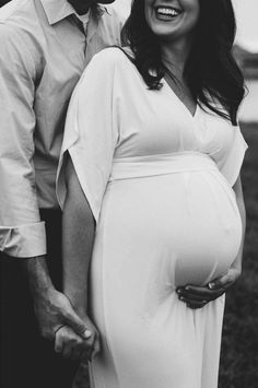 a pregnant woman standing next to a man