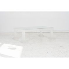 a white table sitting in the middle of a room next to a shadow on the floor