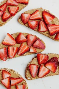 three slices of toast with strawberries on top and peanut butter in the middle for toppings